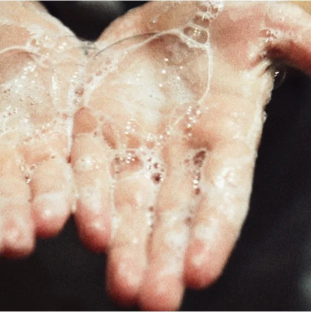 Mousse de shampoing doux dans les mains lors du lavage des cheveux