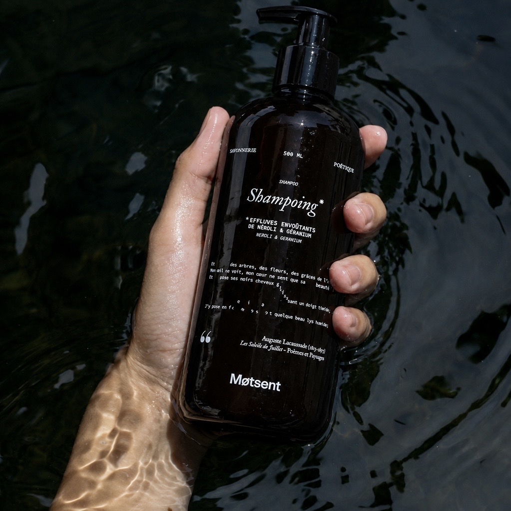 Shampoing naturel parfumé néroli & géranium 500 ml – Motsent Main tenant un flacon de shampoing naturel parfumé Motsent 500 ml au néroli et géranium