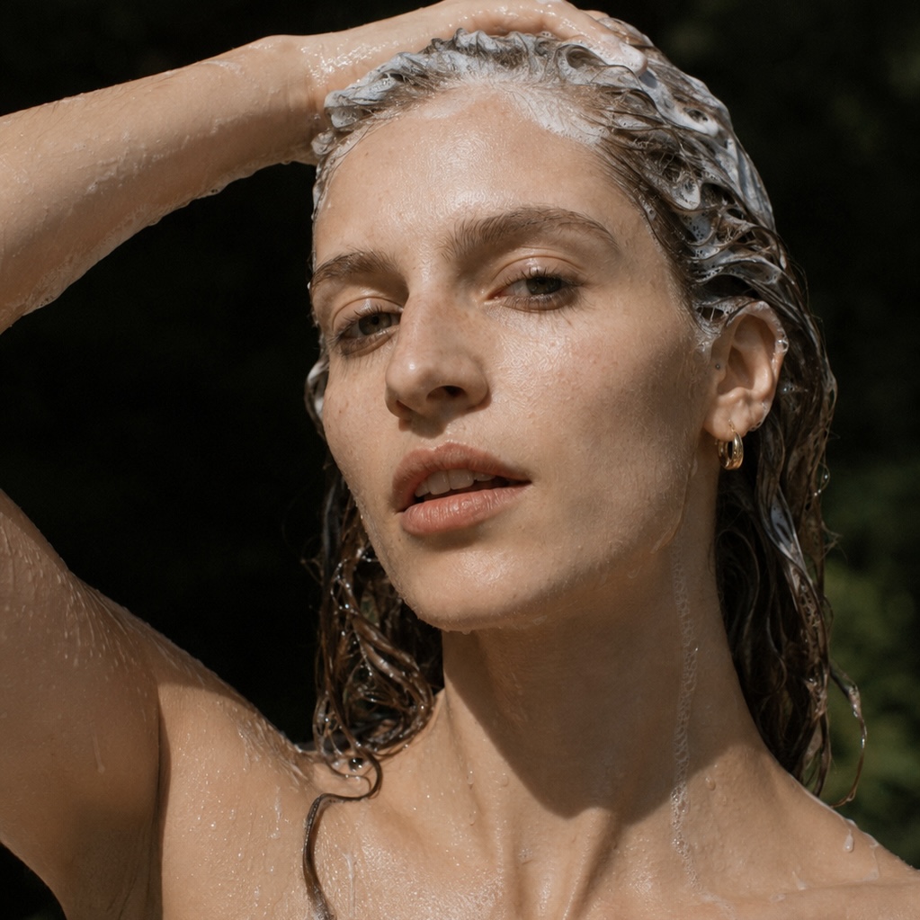 Femme massant ses cheveux mouillés avec un shampoing doux fabriqué en France Motsent